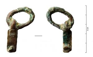 AGH-4021 - Agrafe de harnaisbronzeAgrafe de harnais sur son anneau de suspension, constituée d'un crochet robuste fixé sur une languette rectangulaire de section plate, elle-même percée généralement de deux trous de rivet.