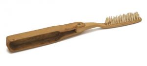 BAD-9004 - Brosse à dents plianteboisTPQ : 1880 - TAQ : 1900Brosse à dents de voyage, dont la partie active, en bois, pivote sur un axe pour venir s'emboîter dans le manche en forme de boîtier allongé, également en bois.