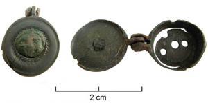 BTS-4016 - Boîte à sceau circulaire : visagebronzeBoîte à sceau circulaire dont le couvercle, pourvu d'une moulure circulaire, est orné d'un ornement riveté en forme de médaillon, représentant un visage enfantin ; fond percé de 4 trous dont un central.