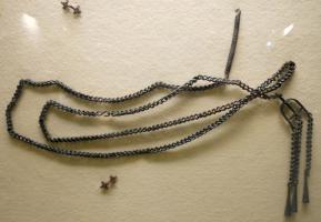 CTN-5001 - ChâtelainebronzeTPQ : 650 - TAQ : 700Longue chaînette refermée par un crochet, et disposant à l'autre extrémités de pendants suspendus à un séparateur.