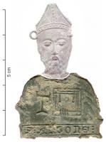 ESP-7025 - Enseigne de pèlerinage : saint AntoineplombEnseigne en forme de buste (chef-reliquaire), barbu, coiffé de la mitre d'évêque. tenant devant lui un tau et un livre; dessous, inscription S:ANTONE: