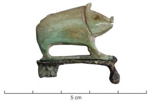 FIB-41002 - Fibule zoomorphe : sanglierbronze, osFibule composite, avec une base à charnière comportant un arc plat, sur lequel est fixé une figurine en os, représentant un sanglier.