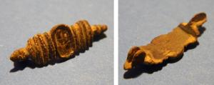 FIB-41388 - Fibule symétrique émailléebronzeBroche constituée d'un médaillon ovale, disposé entre deux séries de moulures resserrées terminées par des boutons.