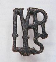 FIB-41763 - Fibule inscrite MARS (ou MARTIS)bronzeTPQ : 100 - TAQ : 300Fibule dont le corps ajouré dessine les lettres superposées d'un monogramme : on lit MARS (ou MARTIS). Au revers, ressort sur axe monté sur une plaquette coulée.