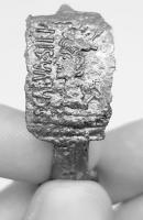 FIB-41869 - Fibule de forme Alésia, type NadinbronzeFibule de type Alésia (pied redressé et percé, charnière repliée vers l'intérieur) dont l'arc est occupé par une plaque rectangulaire à décor figuré accompagné d'une isncription.