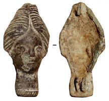 FIB-4390 - Fibule en forme de tête fémininebronzeFibule dont le corps entier représente une tête féminine, limitée vers le cou par une moulure guillochée ; la coiffure montre les cheveux séparés par une raie médiane et tirés en arrière.