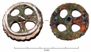 FIB-5046 - Fibule discoïdalebronzeFibule constituée d'un disque ajouré, évoquant peut-être une roue à 4 rayons ou encore une croix inscrite dans un cercle ; cabochon pyramidal au centre; argentée.