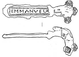 FIB-5084 - Fibule digitéebronzeFibule à arc court, bras transversal orné de bulbes polyédriques avec un autre dans l'axe de la fibule; pied très allongé et plat, avec inscription incrustée.