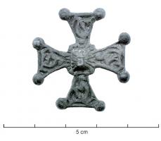 FIB-6030 - Fibule cruciformebronzeFibule en forme de croix, à branches légèrement évasées vers l'extérieur, ornée de profonds reliefs autour d'un motif central également cruciforme; ressort en fer.
