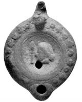 LMP-4129 - Lampe syro-palestinienne Loeschcke VIII : Buste fémininterre cuiteLampe à bec rond. Médaillon décoré d'un buste de femme à gauche facè à une colonnette surmontée d'une flamme, épaule ornée de cercles imprimés. Anse percée.