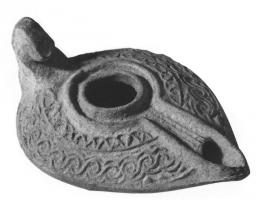 LMP-41513 - Lampe pantoufle byzantine terre cuiteLampe allongée à bec incorporé à canal; épaule décorée de motifs géométriques en relief. Petite anse en forme tête animale stylisée.