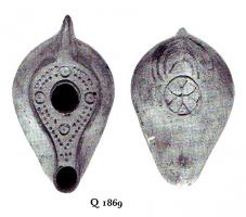 LMP-4842 - Lampe sicilienne tardiveterre cuiteLampe ovoïde à large bec à canal. Médaillon décoré de points et de cercles en relief, base décorée d'une croix inscrite dans un cercle.