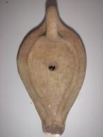 LMP-5089 - Lampe égyptienne tardive Croixterre cuiteLampe en forme de goutte allongée. Disque décoré d'une croix et de cercles. Long bec poursuivant le réservoir. Argile noisette, engobe beige. Grande anse à l'arrière.