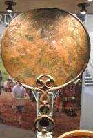 MRR-3001 - Miroir circulaire de type celto-bretonbronzeMiroir constitué d'un disque parfois entaillé à la base, et pas toujours circulaire, sur lequel vient se fixer une anse généralement composée d'une succession de boucles se terminant par un gros anneau.