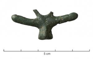 PDH-4036 - Pendant phalliquebronzePendant coulé, symétrique et extrêmement schématique, représentant au-dessus de parties génitales masculines au repos un phallus d'un côté, de l'autre un bras avec la main faisant le geste de la figue (ou plus rarement un deuxième phallus); anneau de suspension placé dans le même plan que le pendant.