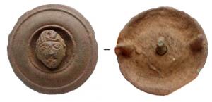 PHA-4006 - Phalère : têtebronzePhalère à simple décor concentrique, centre percé avec un rivet décoratif en forme de tête humaine (Satyre ?); au revers, deux ergots de fixation pour cuir.