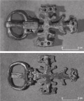 PLB-5542 - Plaque-boucle articulée en forme de croixbronzePlaque en forme de croix latines à empattements complexes, décor de cercles oculés. Boucle articulée en forme d'étrier accosté de deux ergots; ardillon étroit également frappé de cercles oculés.