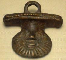 SIT-5003 - SitulebronzeSitule dont l'attache, coulée d'une seule pièce, montre un visage à barbe rayonnante surmonté d'un large épaulement transversal et d'un anneau destiné à recevoir l'anse.