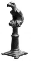 STE-4073 - Statuette zoomorphe : aigle sur tête de bovidébronzeTPQ : 1 - TAQ : 250Figurine représentant en ronde-bosse un aigle posé sur une tête de bovidé, elle-même posée sur un socle (colonne avec une base en gradins ; autel avec quatre colonnes aux angles...), souvent avec quatre petits supports d'angle.