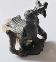STE-4414 - Statuette : aigle et serpentbronzeFigurine d'un aigle saisissant dans ses serres un serpent au corps ondulant, qui redresse une tête monstrueuse à côté de celle du rapace.