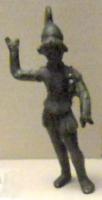 STE-4483 - Mars - Arès cuirassé, brandissant une lancebronzeLe dieu est debout, en appui sur une jambe tandis que l'autre est en retrait. Il porte un casque de type corinthien (?) à haut panache duquel émerge une chevelure bouclée, une cuirasse, une tunique et parfois des jambières. La musculature de son corps est bien marquée. Il brandit une lance, disparue, de la main droite. Le bras gauche est quant à lui tendu vers l'avant : le dieu tenait peut-être dans la main une épée ou un bouclier ; à moins que, prêt à jeter sa lance, le bras gauche ne lui serve à s'équilibrer et à viser une cible. 