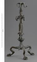 THY-3004 - ThymiaterionbronzeThymiaterion, ou peut-être candélabre, composé d'une figurine humaine formant la plus grande partie d'un support terminé par un motif floral à quatre crochets. L'ensemble de ce dispositif repose sur un trépied dont les pattes de fauves sont séparées par des palmettes.