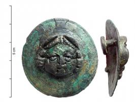 APH-4103 - Applique de harnais : gorgoneionbronzeTPQ : 1 - TAQ : 300Applique circulaire ornée d'un gorgoneion avec deux rivets de fixation.