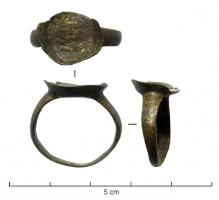BAG-9074 - Bague à cabochonbronzeTPQ : 1200 - TAQ : 1700Bague dont le chaton s'élargit pour recevoir soit une pierre, soit un dispositif enserrant une pierre (cabochon composite).
