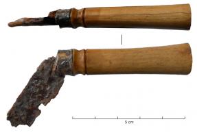CNF-4012 - Canifos, bronze, ferTPQ : 1 - TAQ : 100Canif à manche de section ovale, légèrement plus épaisse à l’arrière que vers l’articulation, marquée par une moulure précédant une virole en tôle de bronze, et rivetée par l’axe en fer de la lame pivotante. La lame en fer, étroite, se replie dans une fente aménagée dans la partie inférieure du manche.