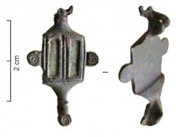 FIB-41197 - Fibule symétrique émailléebronzeFibule symétrique, de petite taille; l'arc rectangulaire est creusé de deux loges parallèles émailléees, rectangulaires, chacune dans un cadre mouluré et guilloché; deux boutons ornés de cercles oculés émergent des côtés ; le pied et la tête sont terminés par des boutons ornés de même.