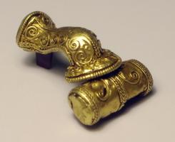 FIB-41618 - Kniefibelor ou bronze plaquéFibule en genou ('Kniefiebel') recouverte d'une épaisse feuille d'or comportant des motifs curcilignes.