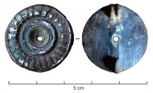 FIB-41654 - Fibule à décor zoomorphe rivetébronzeBroche circulaire avec une moulure sur le pourtour, encochée de traits de nielle; au centre, motif riveté (sans doute zoomorphe), également orné de traits niellés.