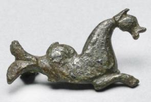 FIB-41680 - Fibule zoomorphe : capricornebronzeFibule en forme de chèvre marine, la queue enroulée, nageant à droite