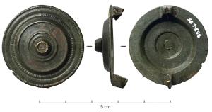 FIB-41892 - Fibule circulaire à décor émaillébronzeBroche circulaire plate, montrant une partie centrale surélevée (creuses par dessous) avec une couronne et un disque central émaillés ; cannelures concentriques guillochées autour ; au revers, charnière entre deux plaquettes coulées.