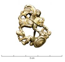 FIB-41917 - Fibule zoomorphe, groupe : cavalier vainqueurargent doréCavalier pointant une lance vers un ennemi tombé à terre (bouclier circulaire), une main levée pour implorer la pitié ; barre de sol.