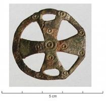 FIB-5274 - Fibule en forme de croix inscritebronzeBroche en forme de croix pattée, ornée d'ocelles, inscrite dans un cercle ajouré.