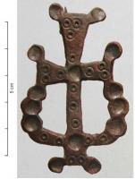 FIB-5275 - Fibule en forme de croixbronzeBroche en forme de croix latine pattée, disques aux angles, posée sur un motif arqué ; décor d'ocelles.