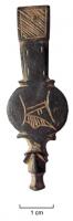FRT-9001 - Ferret à médaillon gravébronzeFerret en trois parties : l'attache supérieure rivetée sur l'extrémité de la ceinture, avec un décor gravé; une partie médiane en forme de médaillon gravé, en général avec une ou deux lettres gothiques; un lest en forme de tête animale.