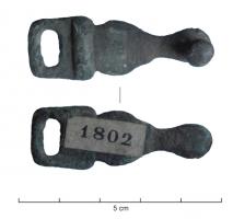 IND-4129 - Bouton à anneau ?bronzeAgrafe allongée, comportant d'un côté une bélière et de l'autre un rivet coulé pour la fixation sur du cuir.