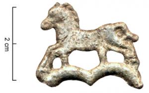 IND-9034 - Fragment d'objet : chevalplomb, étainPartie sommitale d'un objet brisé en plomb, avec le  départ de deux arcs sous les sabots d'un cheval galopant à gauche. 