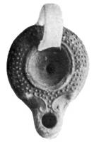 LMP-4030 - Lampe à globules et bec à volutesterre cuiteLampe à bec rond avec anse en ruban appliquée; épaule décorée avec globules moulés; disque vide; bec en ogive à volutes