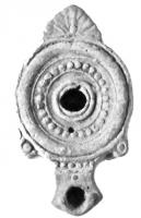 LMP-4084 - Lampe syro-palestinienneterre cuiteLampe à bec en enclume avec volutes; disque décoré d'un cercle de globules; épaule nue; sur le début du bec, ligne de globules; anse en forme de feuille.