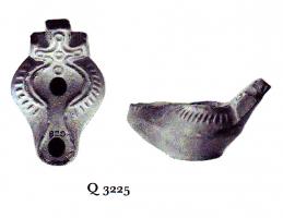 LMP-41404 - Lampe byzantine Croix terre cuiteLampe à bec long à canal; corps massif; épaule ornée de traits centripètes en relief; anse plastique en forme de croix.