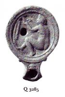 LMP-41439 - Lampe Loeschcke I dérivé : Vénusterre cuiteLampe ronde à bec en enclume décoré par une coupe en relief.  Médaillon décoré de Vénus assise se regardant dans le miroir devant un palmier. 