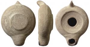 LMP-5275 - Lampe africaine tournée ferméeterre cuiteTPQ : 500 - TAQ : 600Tournée anse verticale en tenon pincé, rapportée. Réservoir circulaire de profil globulaire. Bandeau penché vers l'extérieur. Disque en simple cuvette profonde, grand trou d'alimentation. Petit bec arrondi, rapporté, sans délimitation. Base plate en relief.   