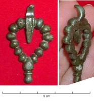 PDH-4117 - Pendant de harnaisbronzePendant en forme de boucle ovoïde, composée d'une succession de globules, au sommet un écu ou une feuille en V allongé, surmonté d'un anneau; bouton mouluré à la base.