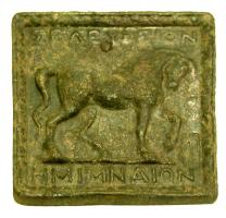 PDS-3002 - Poids grec : Séleucie de PiériebronzeTPQ : -300 - TAQ : 1Plaque carrée coulée, avec un relief sur la face supérieur : cheval marchant à droite, tête baissée, encadré de deux inscriptions : au-dessus, [[SELEUKION]]; au-dessous, [[HMIMNAION]].