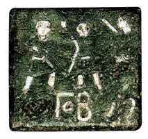 PDS-5020 - Poids quadrangulaire à décor figuré : Γ° B (2 unciae)bronze, argentPoids épais, de forme carrée, orné sur une face d'une scène figurée incisée, aux détails rehaussés d'argent : deux personnages chassant, avec arc et bouclier ; à droite, un personnage de plus grande taille semble déposer une couronne sur la tête de l'un d'eaux. Inscription en lettres grecques, incrustées d'argent : Γ° B.