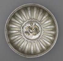 PHI-4003 - Phiale à médaillon figuréargentCoupe basse, à panse lisse ou godronnée, mettant en relief un médaillon central à décor figuré.