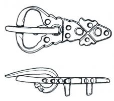 PLB-5189 - Plaque-boucle rigidebronzeTPQ : 625 - TAQ : 675Plaque-boucle non articulée, à boucle ovale encochée pour le repos d'ardillon ; la plaque est très allongée, formant une languette aux contours découpés, couverte de cercles oculés et percée d'ajours ; au revers, bélières coulées permettant de fixer la boucle sur la ceinture.